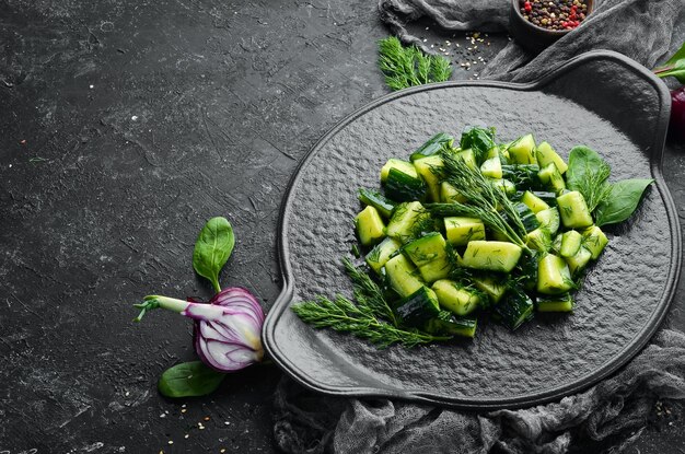 Vegans salad with cucumber and dill on a black plate Rustic style Top view Free space for your text