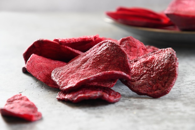 Vegetable beetroot chips on a gray background Vegan snack Close up