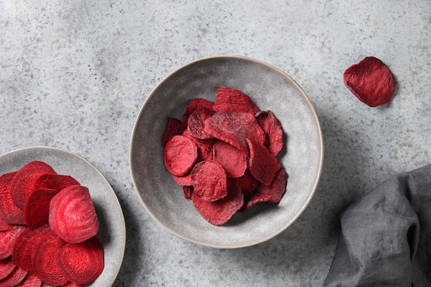 Vegetable beetroot chips in gray bowl on a white background