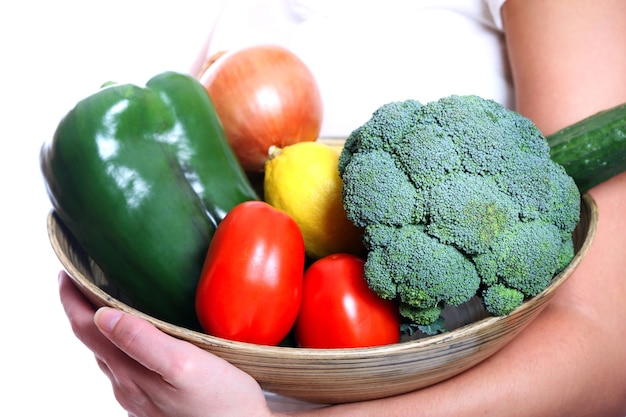 若い女性の腕の中で野菜のボウル