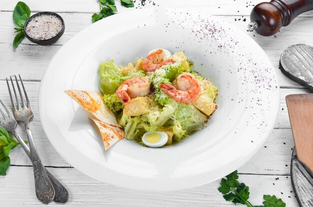 Фото Овощной салат цезарь с креветками в тарелке вид сверху свободное место для текста деревенский стиль