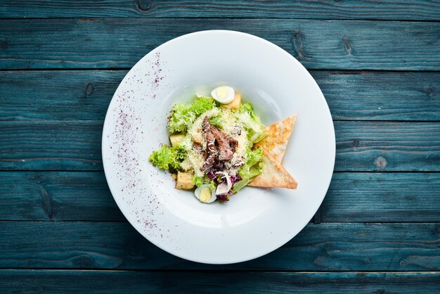 Vegetable Caesar Salad with Veal In the plate Top view Free space for your text Rustic style