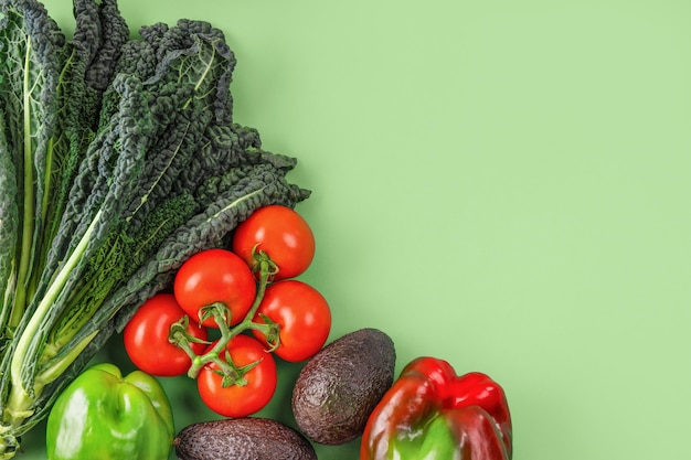 Vegetable creative layout on green background. Flat lay, copy space