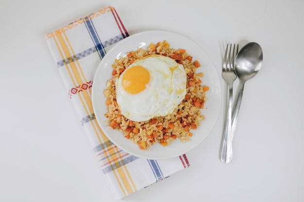 Vegetable Fried Rice with a sunny side up on a White Plate on the White Background Directly Above Photo