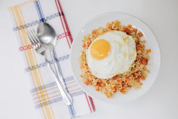 Vegetable Fried Rice with a sunny side up on a White Plate on the White Background Directly Above Photo