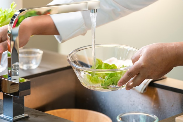 野菜のグリーン オークの水をガラスのボウルで洗った