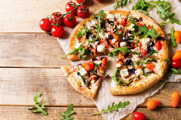 Vegetable italian pizza with tomatos on wodeen background, copy space, top view