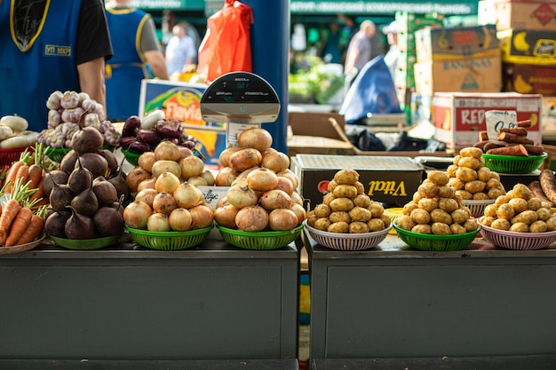 Vegetable market. Many different vegetables in multi-colored baskets next to each other are sold.