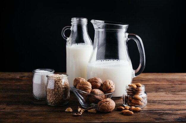 Vegetable milk on wood background, almond milk, walnut milk, rice milk, and coconut milk