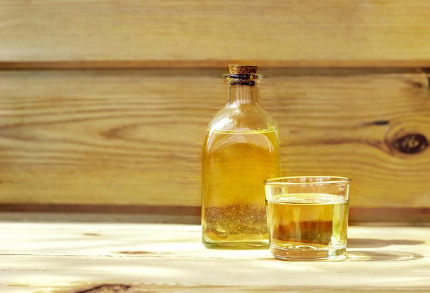 Vegetable oil in a bottle glass on the wooden background