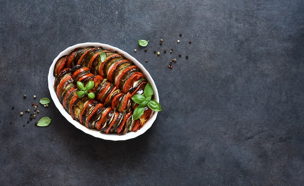 Vegetable ratatouille on a black concrete background, top view.