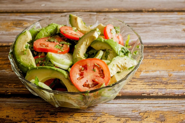 Insalata di verdure in una ciotola di vetro su un tavolo di legno. verdure, cibo sano.