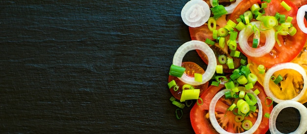 Vegetable salad ingredients - tomatoes, cucumbers, onion and greens