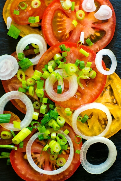 Vegetable salad ingredients, tomatoes, cucumbers, onion and greens