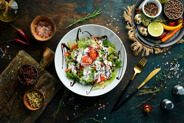 Vegetable salad lettuce tomatoes cucumber and cream sauce Caesar Top view Top view Rustic style