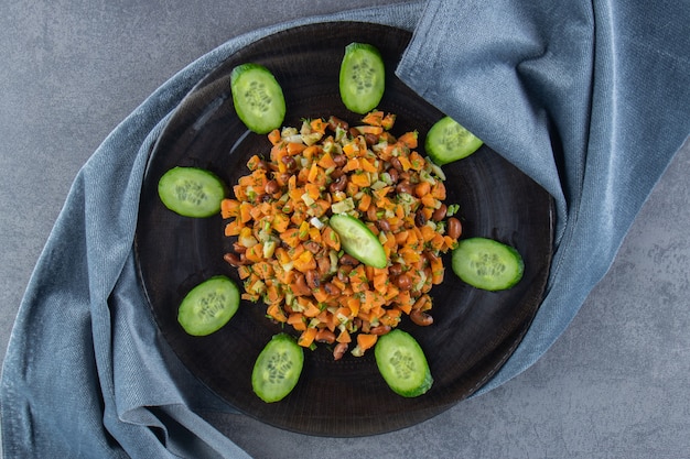 大理石の表面のタオルの上の皿の上の野菜サラダ。