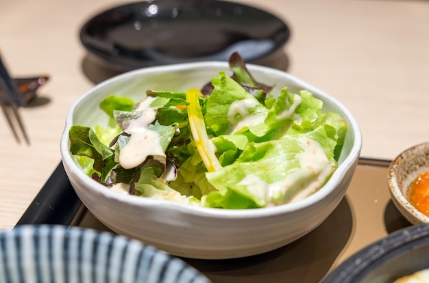 Vegetable salad in white bowl on tray