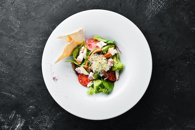 vegetable salad with brie cheese cherry tomatoes and spinach in the plate top view free space for your text rustic style