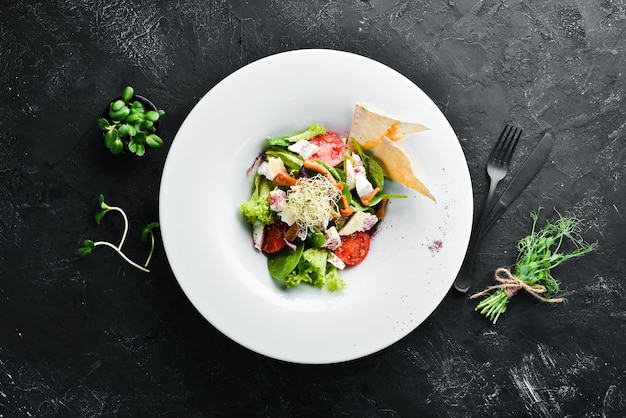 vegetable salad with brie cheese cherry tomatoes and spinach in the plate top view free space for your text rustic style