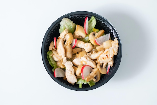 Vegetable salad with chicken in a disposable bowl