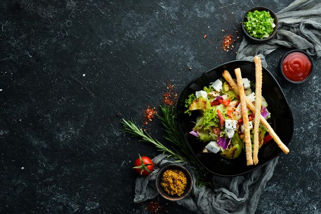 黒いプレートにチキンズッキーニとフェタチーズを添えた野菜サラダ上面図テキスト用の空きスペース