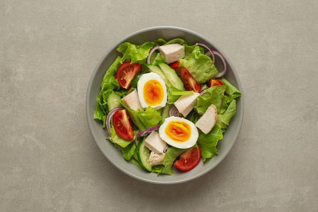 Vegetable salad with an egg on a gray background