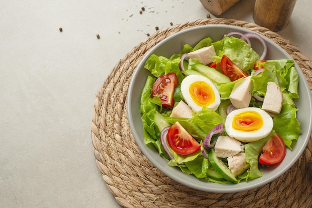 Vegetable salad with an egg on a gray background