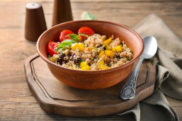 Vegetable salad with quinoa on wooden table