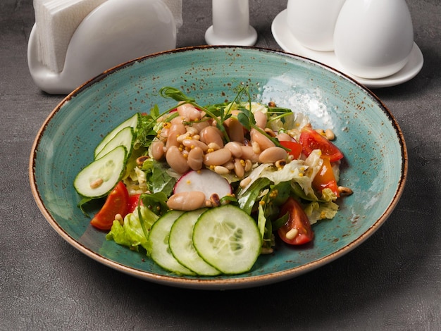 Vegetable salad with white beans in the restaurant concept vegetarian food