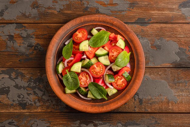 Vegetable salad on a wooden background, top view