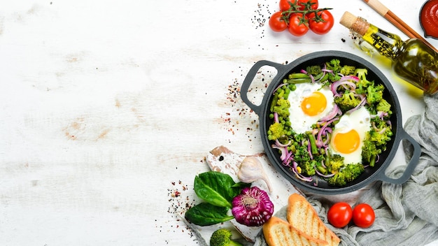 Shakshuka di verdure in padella uova fritte con verdure broccoli piselli fagioli cipolle vista dall'alto spazio libero per il testo