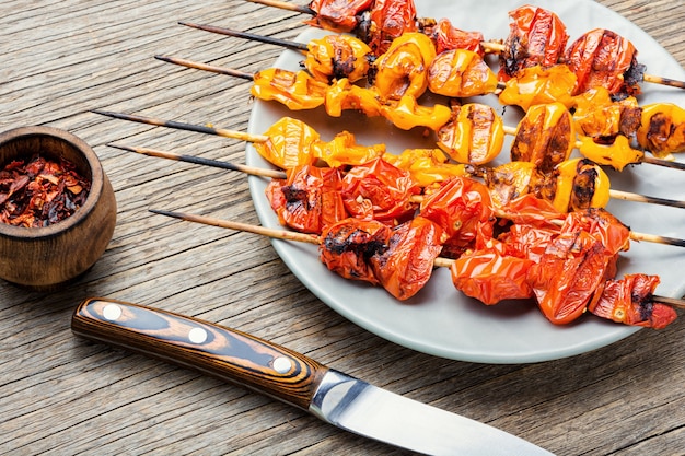 Vegetable skewers on a wooden background.Vegetable skewers of tomatoes, cherry tomatoes.