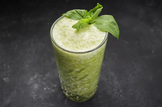 Vegetable smoothie with spinach on a dark background