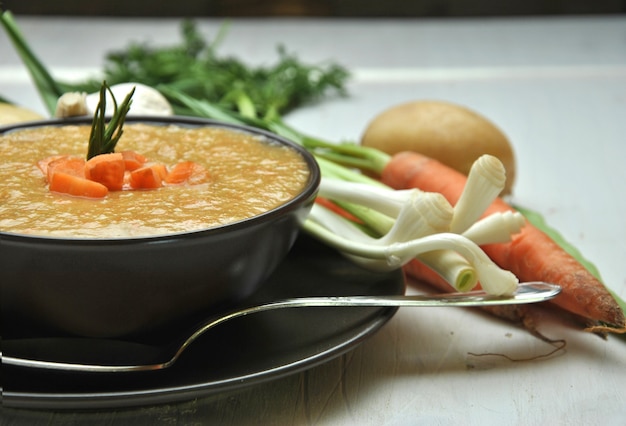 Zuppa di verdure accompagnata con carote, patate e aglio