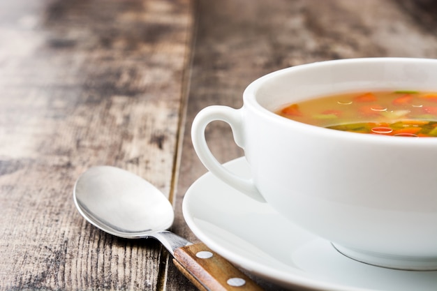 Photo vegetable soup in bowl on wooden table