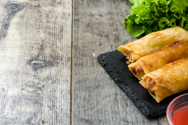 Vegetable spring rolls on wooden table background copy space