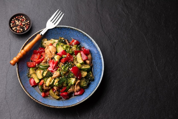 Scalpore di verdure fritte sul piatto blu