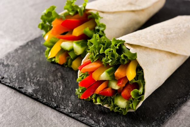 Vegetable tortilla wraps on gray stone background