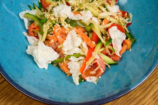 Овощной вегетарианский салат с помидорами, перцем и луком на деревянном столе. здоровый салат со свежими спелыми летними овощами