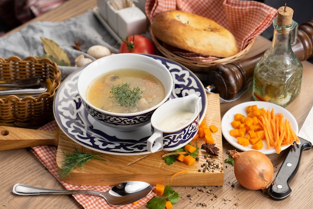 Vegetable vegetarian soup with mushrooms carrots and dill in a plate with a traditional uzbek