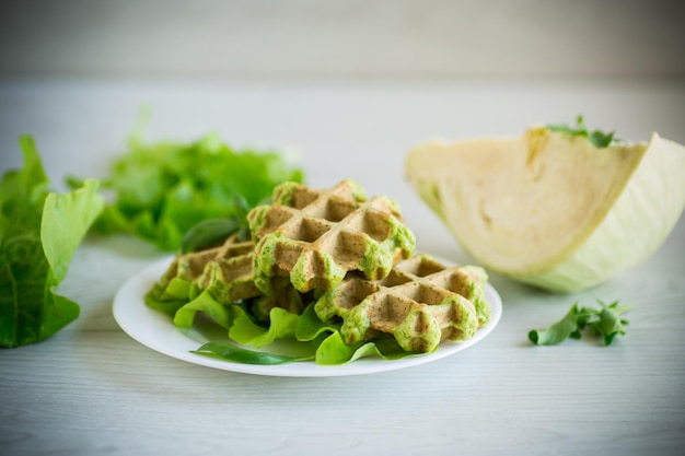 Vegetable waffles cooked with herbs in a plate on a wooden table