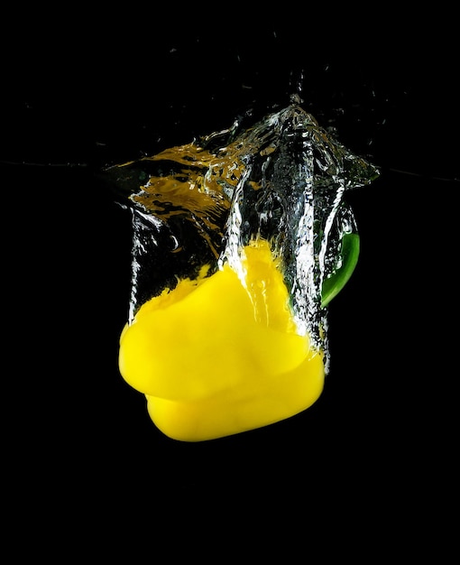 Овощной желтый перец в воде на фоне пузырей