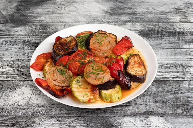 Vegetables baked vegetables on a wooden white background