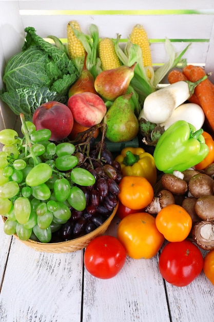 Vegetables in basket on white wooden box background