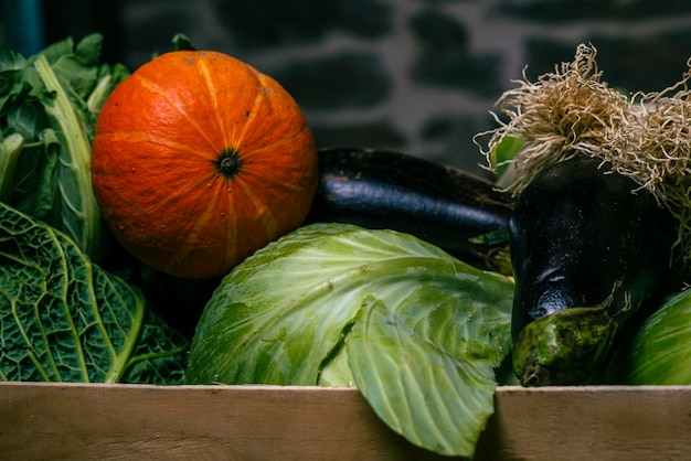 Photo vegetables in a box near the background cabbage carrot eggplant leek pumpkin