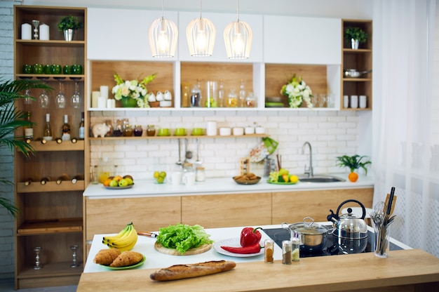 Vegetables and bread placed on wooden table.