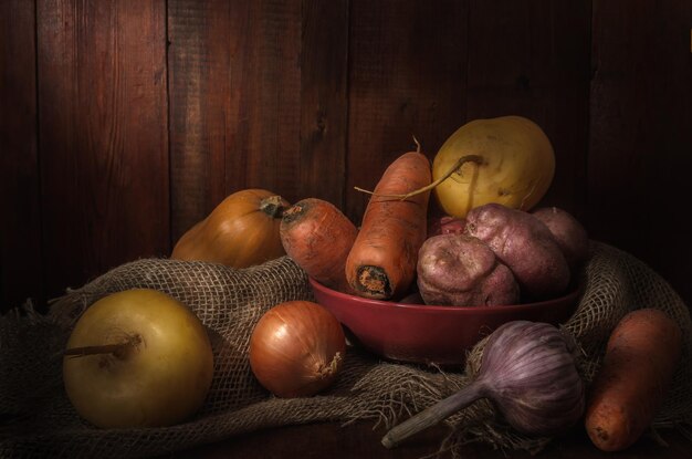 Vegetables in a clay bowl on a dark wooden background