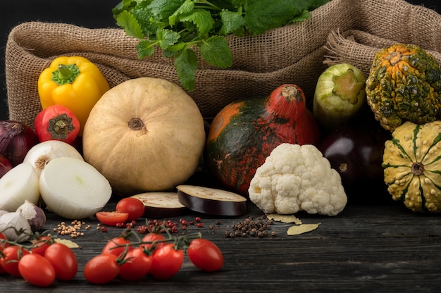 Vegetables on a dark wooden background, beautifully decorated still life of vegetables.