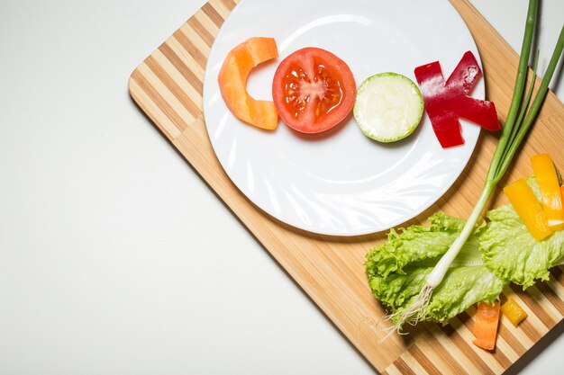 Vegetables in the form of letters on a cutting board