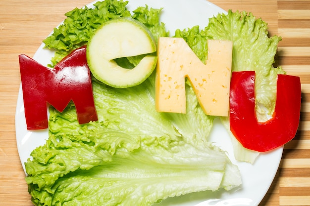 Vegetables in the form of letters on a cutting board